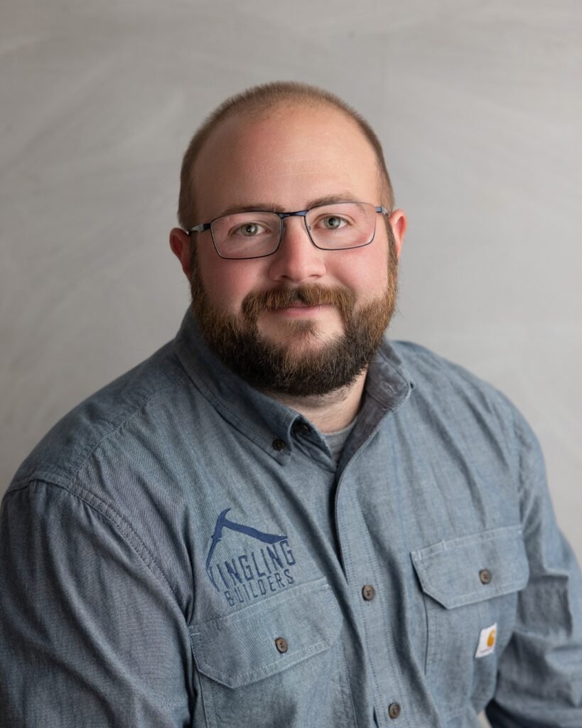 Portrait of a bearded man wearing glasses and a blue work shirt with the Yingling Builders logo