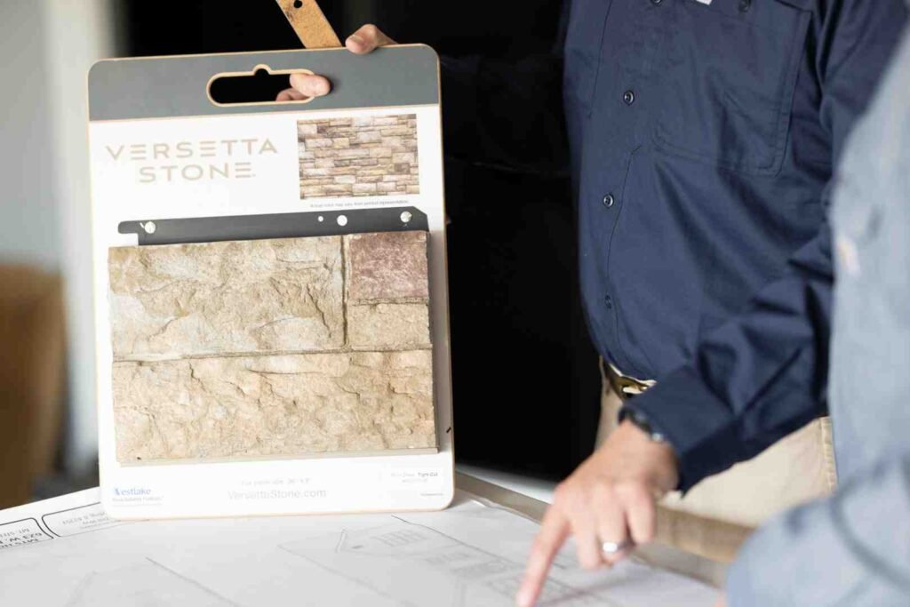 Stone veneer sample board being shown over architectural plans