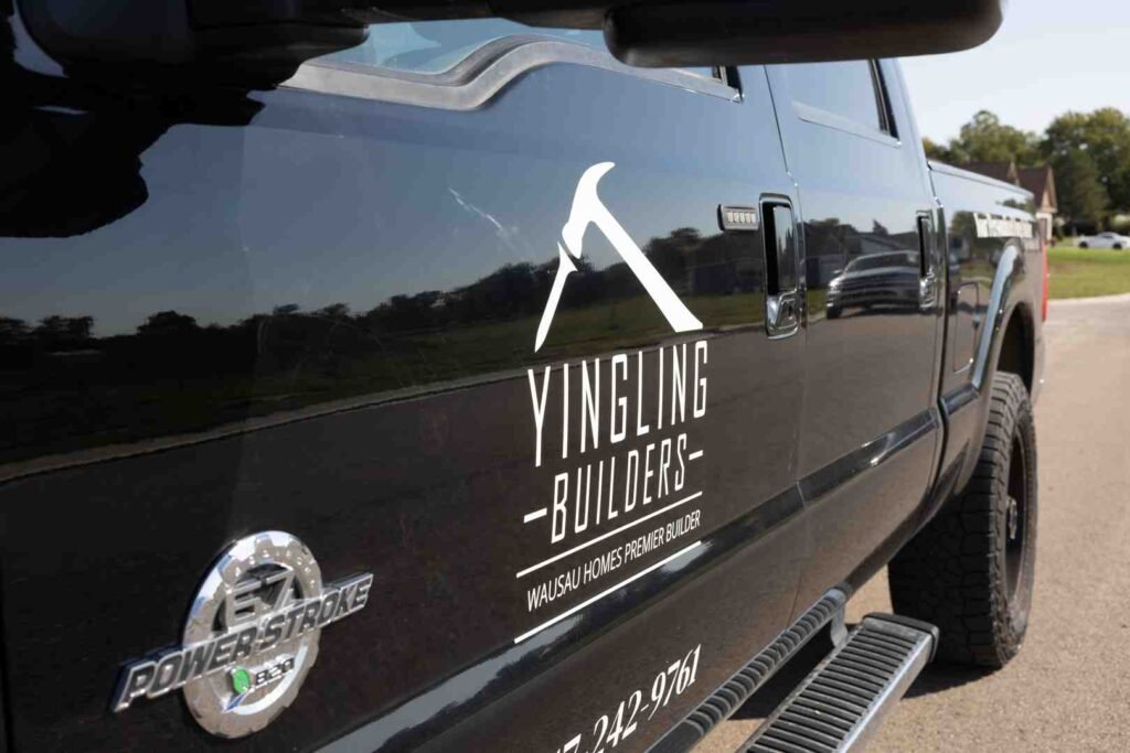 Black pickup truck with Yingling Builders logo and Wausau Homes Premier Builder text on the door