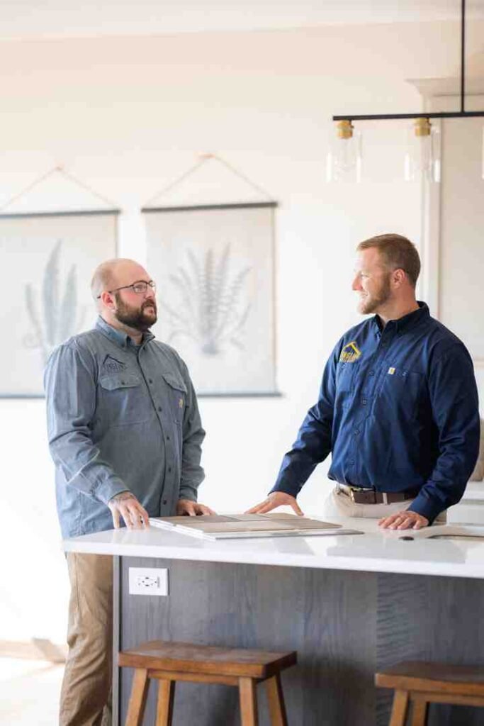 Two men talking at a kitchen island in a bright home interior