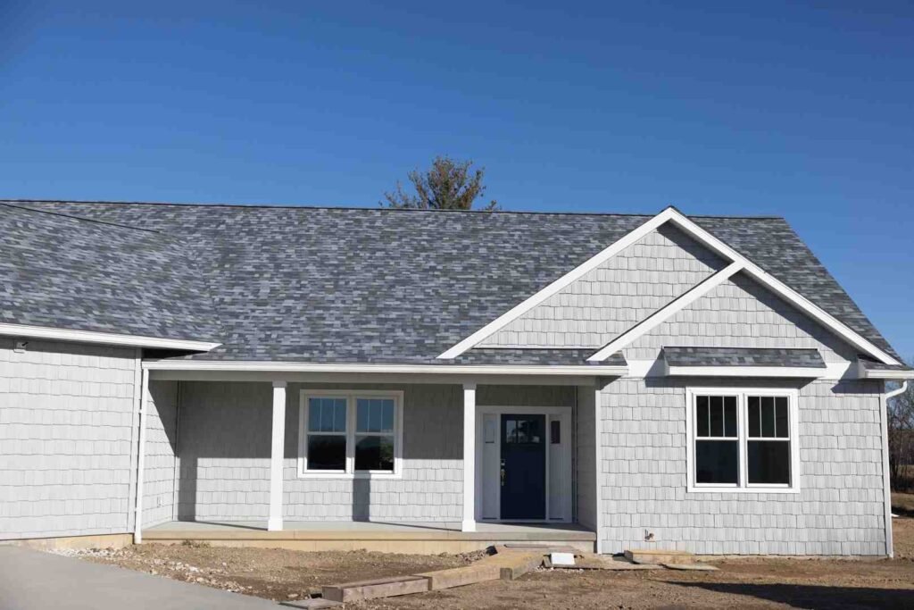 Front view of a gray house with a covered porch and blue front door