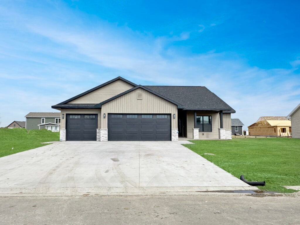 Newly built single-story house with a three-car garage and a wide concrete driveway