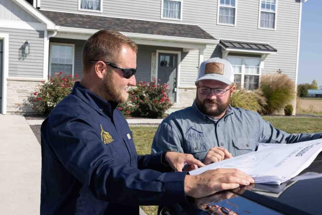 Licensed home builder reviewing plans at a custom home construction site - Licensed home builder